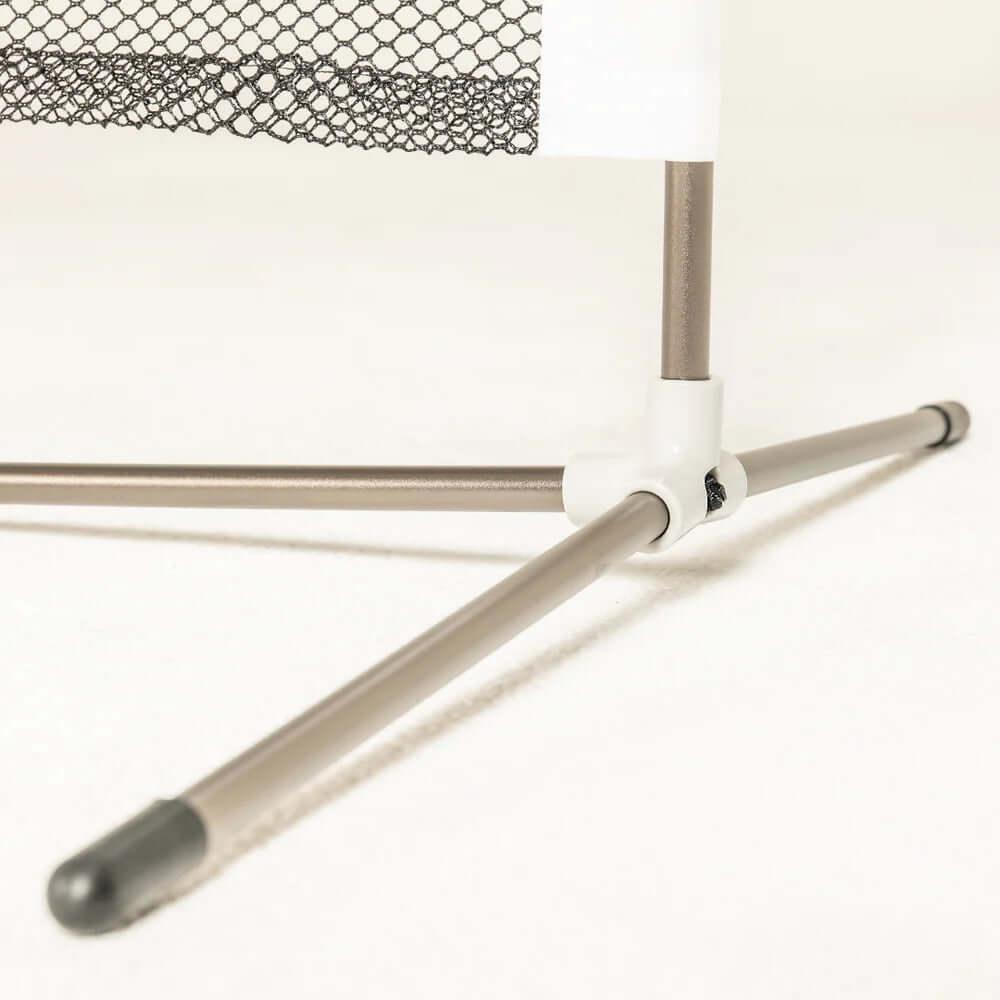 Close-up of metal frame base with net, portable sports net stand on white surface